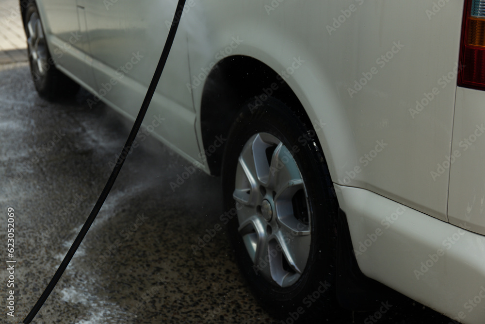 A man washes a car at a self-service car wash