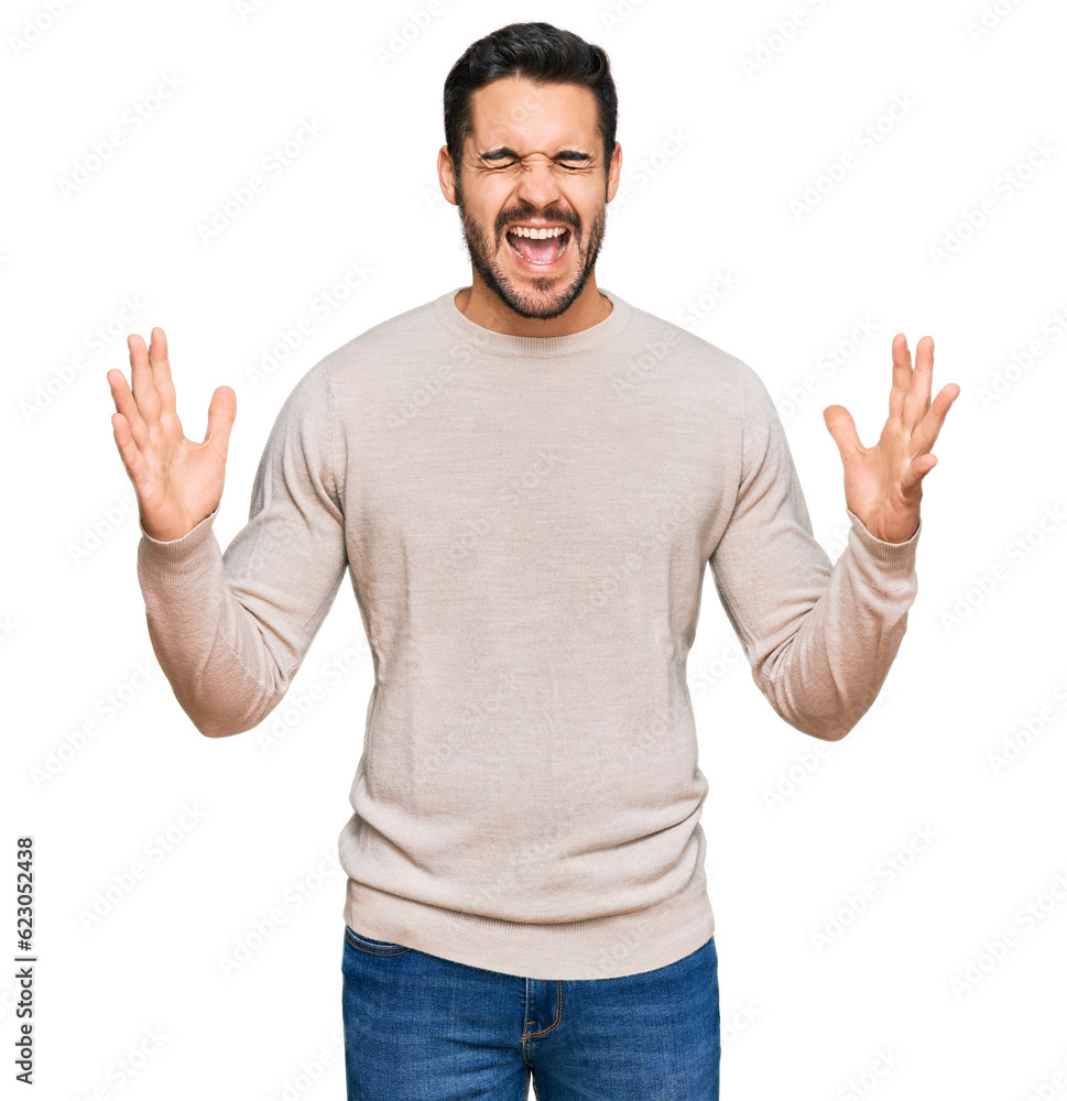 Young hispanic man wearing casual clothes celebrating mad and crazy for success with arms raised and closed eyes screaming excited. winner concept Young hispanic man wearing casual clothes celebrating mad and crazy for success with arms raised and closed eyes screaming excited. winner concept