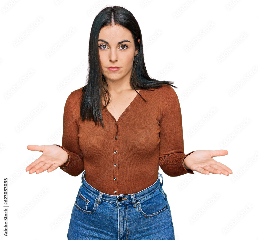 Young hispanic woman wearing casual clothes clueless and confused expression with arms and hands raised. doubt concept. Young hispanic woman wearing casual clothes clueless and confused expression with arms and hands raised. doubt concept.