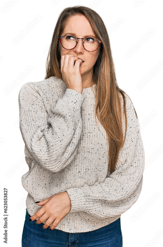 Young blonde woman wearing casual sweater and glasses looking stressed and nervous with hands on mouth biting nails. anxiety problem.