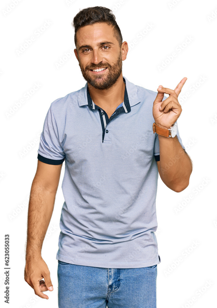 Handsome man with beard wearing casual clothes with a big smile on face, pointing with hand finger to the side looking at the camera. Handsome man with beard wearing casual clothes with a big smile on face, pointing with hand finger to the side looking at the camera.