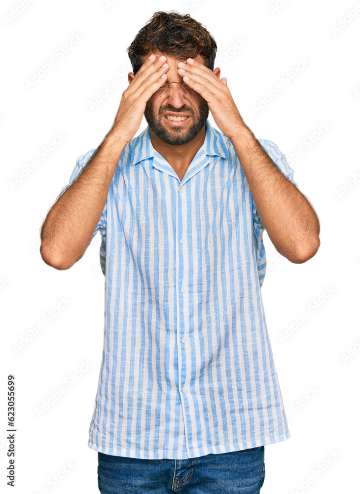 Handsome young man with beard wearing casual fresh shirt with hand on head for pain in head because stress. suffering migraine. Handsome young man with beard wearing casual fresh shirt with hand on head for pain in head because stress. suffering migraine.