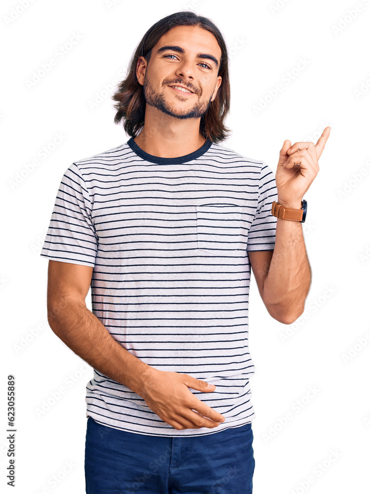 Young handsome man wearing casual clothes with a big smile on face, pointing with hand and finger to the side looking at the camera. Young handsome man wearing casual clothes with a big smile on face, pointing with hand and finger to the side looking at the camera.