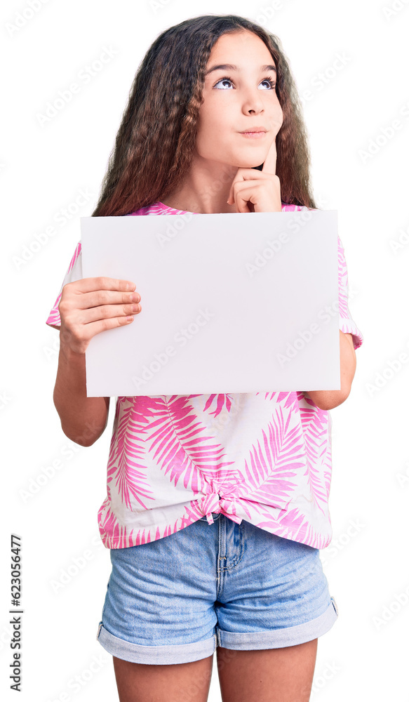 Cute hispanic child girl holding blank empty banner serious face thinking about question with hand on chin, thoughtful about confusing idea Cute hispanic child girl holding blank empty banner serious face thinking about question with hand on chin, thoughtful about confusing idea