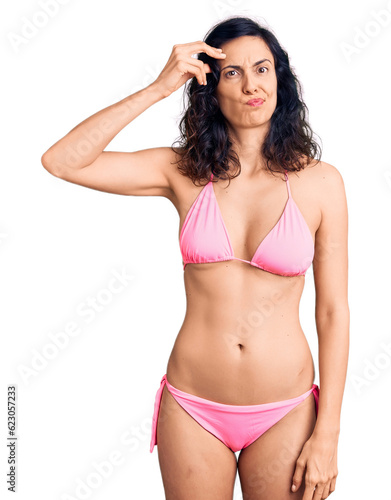 Young beautiful hispanic woman wearing bikini worried and stressed about a problem with hand on forehead, nervous and anxious for crisis © Krakenimages.com