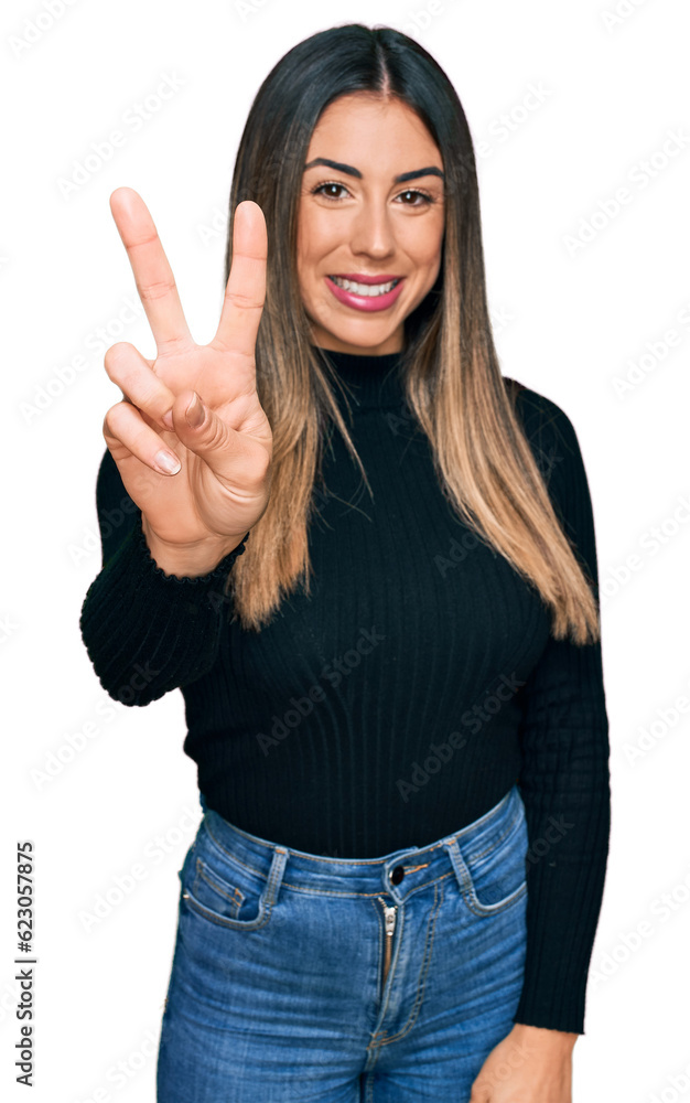 Young hispanic woman wearing casual clothes showing and pointing up with fingers number two while smiling confident and happy. Young hispanic woman wearing casual clothes showing and pointing up with fingers number two while smiling confident and happy.