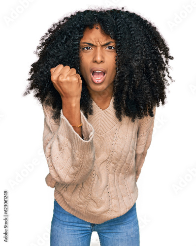 Young african american girl wearing casual clothes angry and mad raising fist frustrated and furious while shouting with anger. rage and aggressive concept.