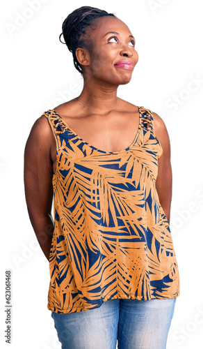 Young african american woman wearing casual clothes smiling looking to the side and staring away thinking.