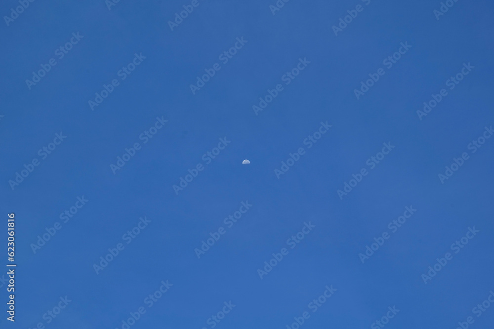 Blue sky with white clouds and a moon in the clear day. Blue sky with white clouds and a moon in the clear day.