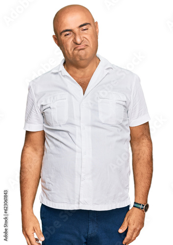 Mature middle east man with mustache wearing casual white shirt looking sleepy and tired, exhausted for fatigue and hangover, lazy eyes in the morning.