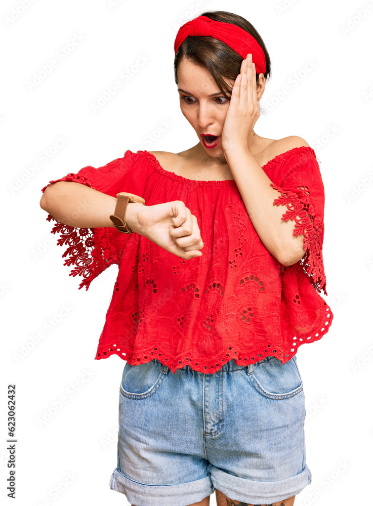 Young brunette woman with short hair wearing casual summer clothes and diadem looking at the watch time worried, afraid of getting late Young brunette woman with short hair wearing casual summer clothes and diadem looking at the watch time worried, afraid of getting late