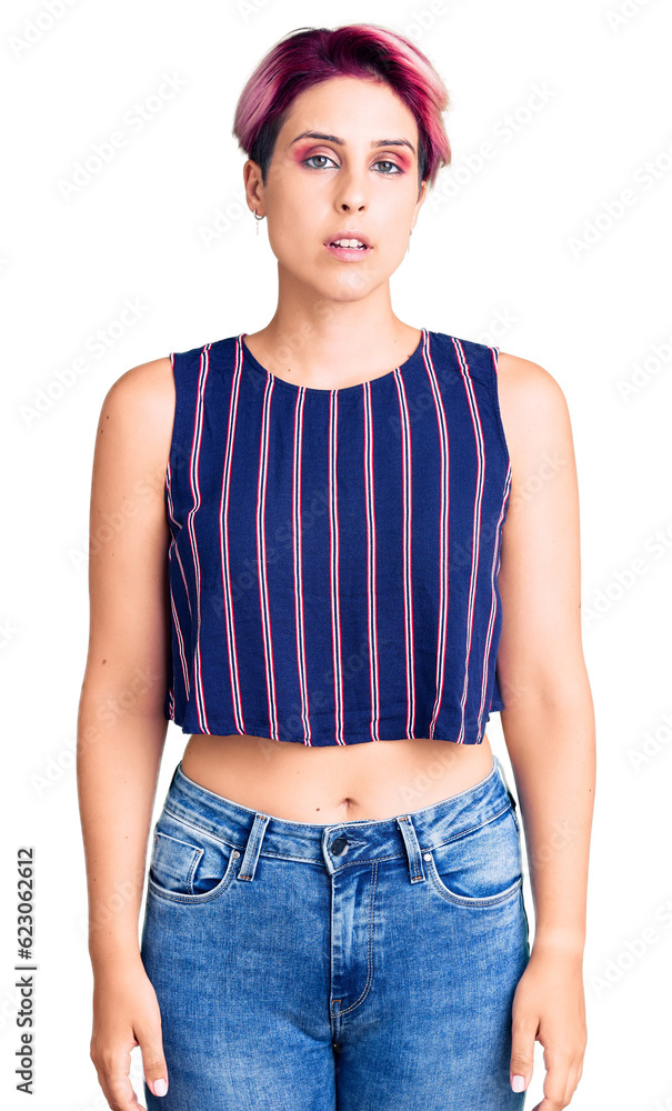 Young beautiful woman with pink hair wearing casual clothes relaxed with serious expression on face. simple and natural looking at the camera. Young beautiful woman with pink hair wearing casual clothes relaxed with serious expression on face. simple and natural looking at the camera.