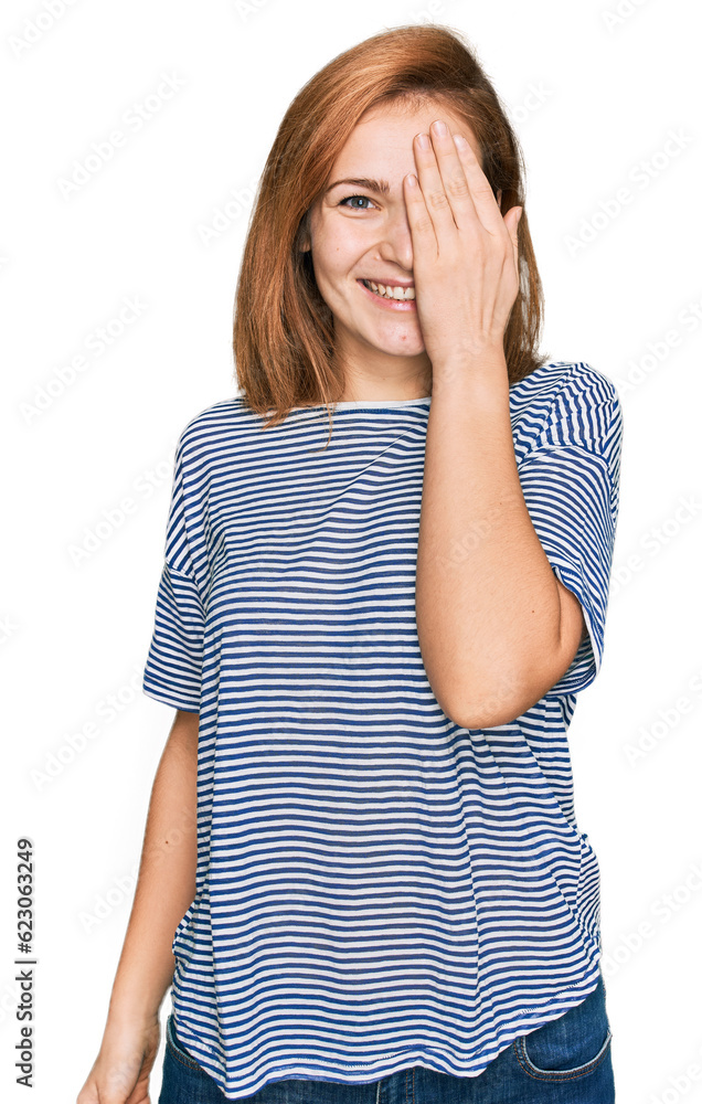 Young caucasian woman wearing casual clothes covering one eye with hand, confident smile on face and surprise emotion. Young caucasian woman wearing casual clothes covering one eye with hand, confident smile on face and surprise emotion.