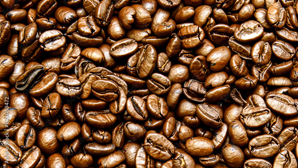 Obraz premium A lot of roasted coffee beans which have been scattered all over the surface used as a background