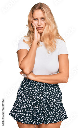 Foto Young blonde girl wearing casual white tshirt thinking looking tired and bored with depression problems with crossed arms