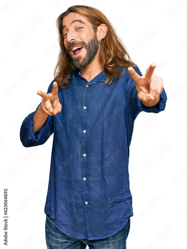 Attractive man with long hair and beard wearing casual clothes smiling looking to the camera showing fingers doing victory sign. number two. Attractive man with long hair and beard wearing casual clothes smiling looking to the camera showing fingers doing victory sign. number two.
