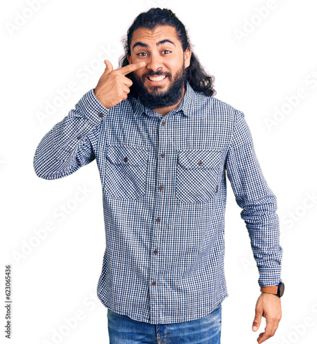 Young arab man wearing casual clothes pointing with hand finger to face and nose, smiling cheerful. beauty concept