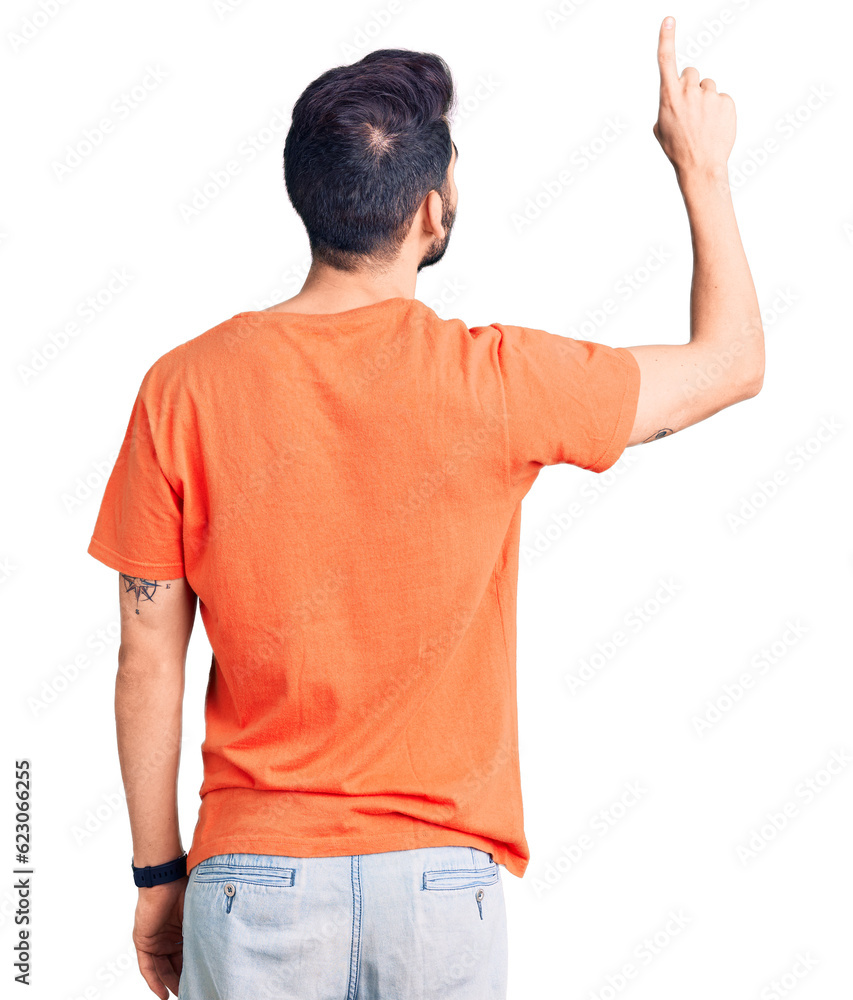 Young handsome man with beard wearing casual t-shirt posing backwards pointing ahead with finger hand Young handsome man with beard wearing casual t-shirt posing backwards pointing ahead with finger hand