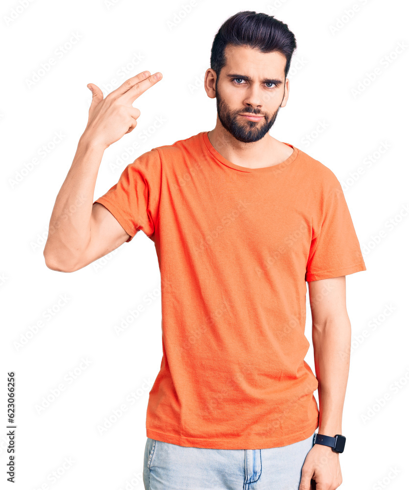 Young handsome man with beard wearing casual t-shirt shooting and killing oneself pointing hand and fingers to head like gun, suicide gesture. Young handsome man with beard wearing casual t-shirt shooting and killing oneself pointing hand and fingers to head like gun, suicide gesture.