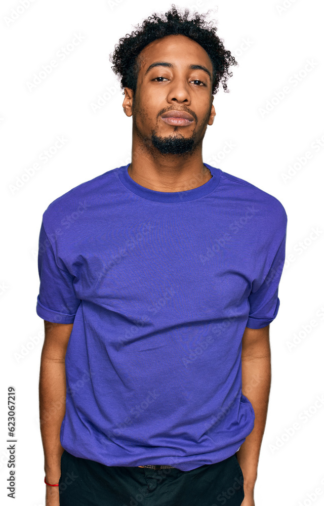 Young african american man with beard wearing casual purple t shirt relaxed with serious expression on face. simple and natural looking at the camera. Young african american man with beard wearing casual purple t shirt relaxed with serious expression on face. simple and natural looking at the camera.