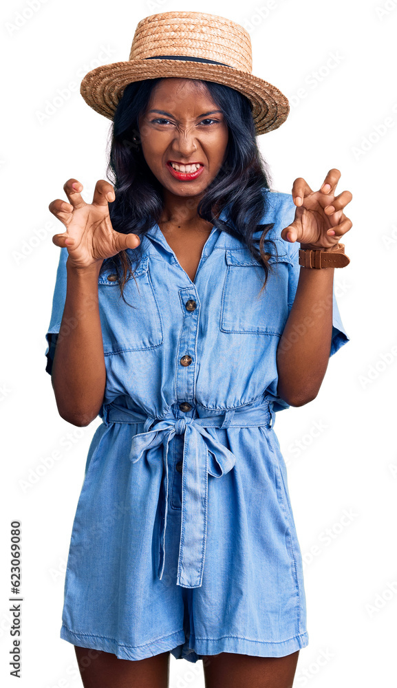Young indian girl wearing summer hat smiling funny doing claw gesture as cat, aggressive and sexy expression Young indian girl wearing summer hat smiling funny doing claw gesture as cat, aggressive and sexy expression