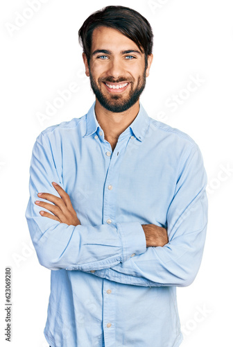 Hispanic man with blue eyes wearing business shirt happy face smiling with crossed arms looking at the camera. positive person.