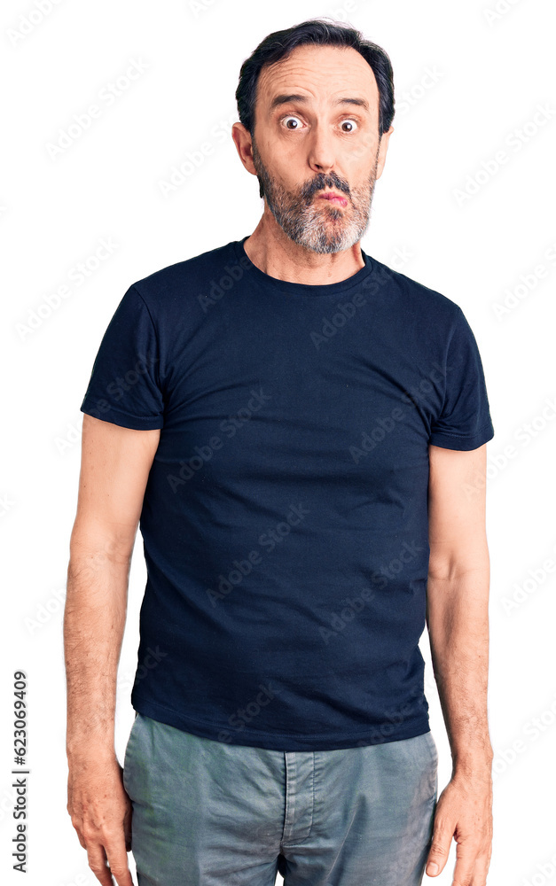 Middle age handsome man wearing casual t-shirt making fish face with lips, crazy and comical gesture. funny expression. Middle age handsome man wearing casual t-shirt making fish face with lips, crazy and comical gesture. funny expression.