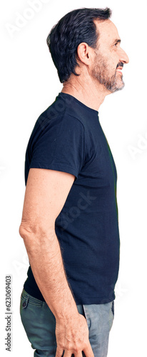 Middle age handsome man wearing casual t-shirt looking to side, relax profile pose with natural face with confident smile.