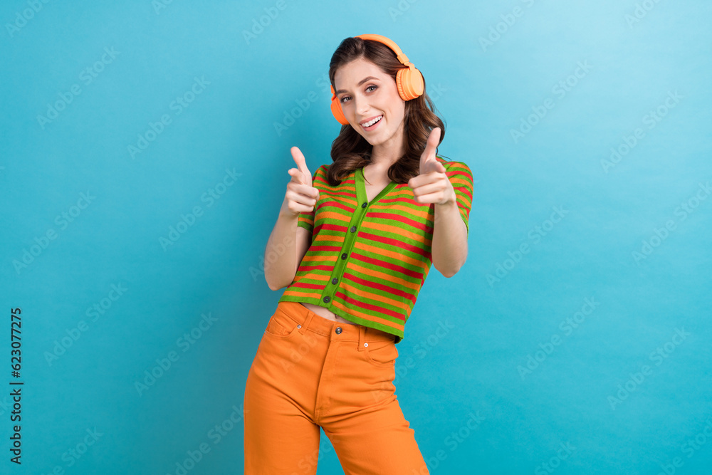 Photo of youngster woman direct fingers you cool party invitation listen earphones prepare for dance battle isolated on blue background Photo of youngster woman direct fingers you cool party invitation listen earphones prepare for dance battle isolated on blue background