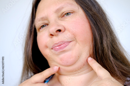 close up part face mature woman 55 years old, human fat neck, side view, double saggy chin, Aging and Facial Appearance, age-related skin changes, cosmetic anti-aging procedures, skin tightening photo