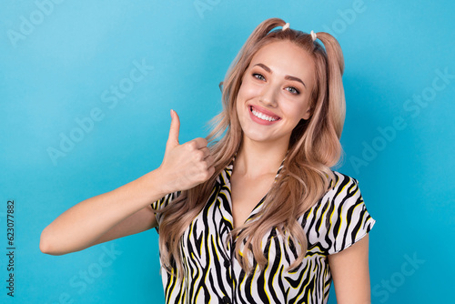 Portrait of toothy beaming woman with stylish hairstyle wear zebra shirt showing thumb up nice job isolated on blue color background © deagreez