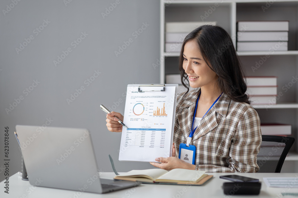 Young beautiful asian woman working in corporate office, businesswoman working in office attentively to grow and modernize start-up business, she is analyzing company's market and financial data. Young beautiful asian woman working in corporate office, businesswoman working in office attentively to grow and modernize start-up business, she is analyzing company's market and financial data.