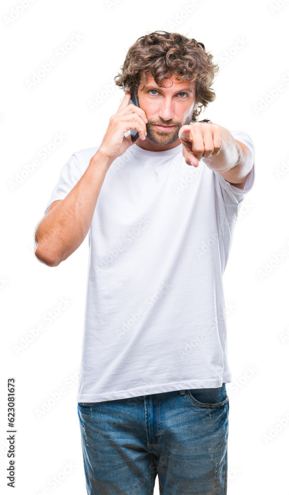 Handsome hispanic man model talking on smartphone over isolated background pointing with finger to the camera and to you, hand sign, positive and confident gesture from the front Handsome hispanic man model talking on smartphone over isolated background pointing with finger to the camera and to you, hand sign, positive and confident gesture from the front