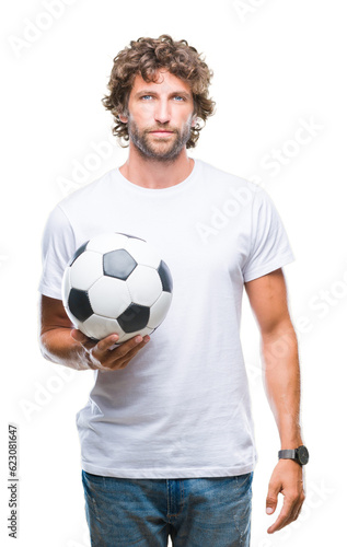 Handsome hispanic man model holding soccer football ball over isolated background with a confident expression on smart face thinking serious