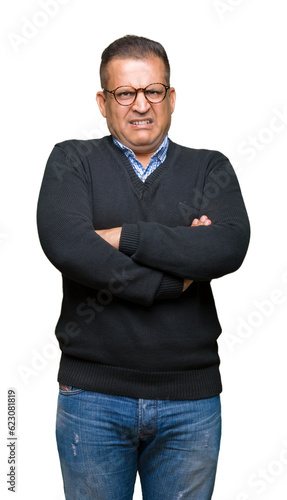 Middle age bussines arab man wearing glasses over isolated background skeptic and nervous, disapproving expression on face with crossed arms. Negative person.