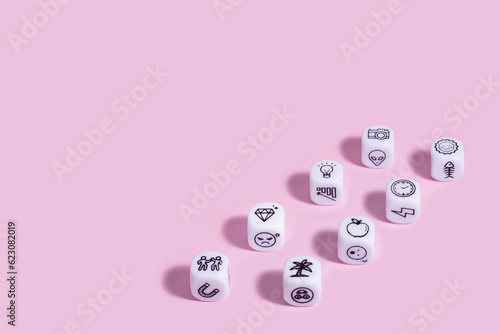 Story dice cubes on pastel pink backround.