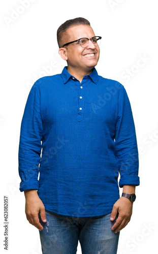 Middle age arab man wearing glasses over isolated background smiling looking side and staring away thinking.