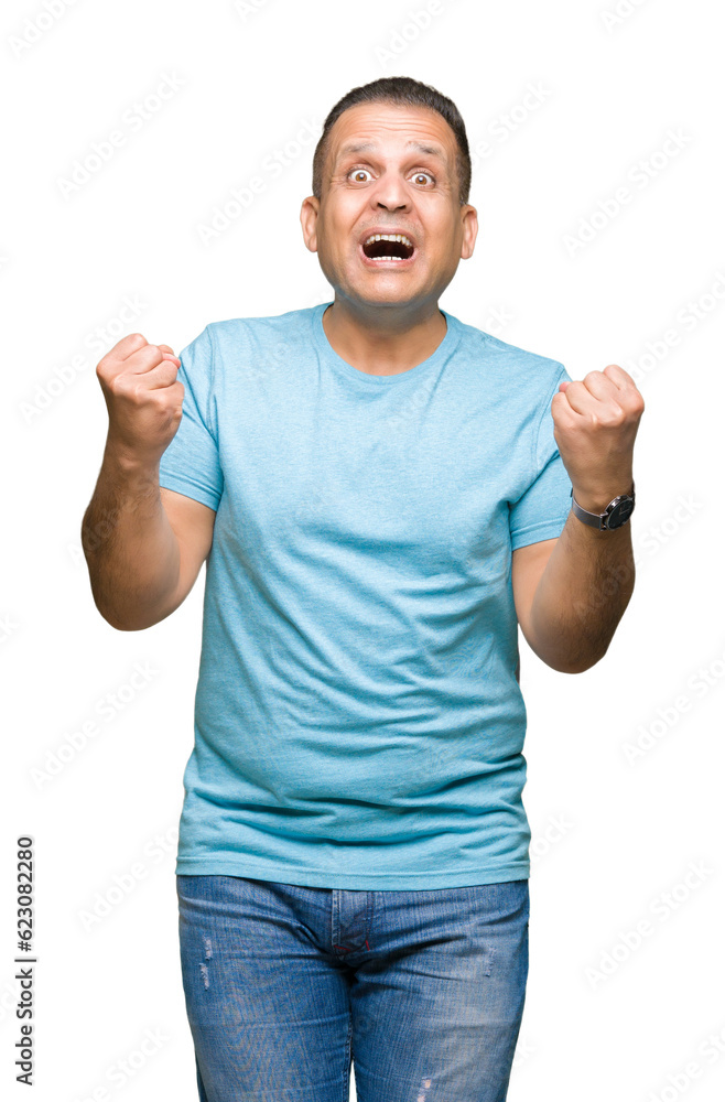 Middle age arab man wearing blue t-shirt over isolated background celebrating surprised and amazed for success with arms raised and open eyes. Winner concept. Middle age arab man wearing blue t-shirt over isolated background celebrating surprised and amazed for success with arms raised and open eyes. Winner concept.