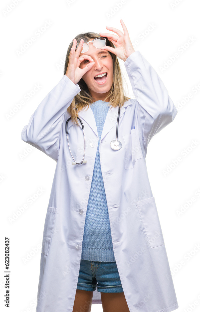 Young beautiful doctor woman headphones over isolated background doing ok gesture with hand smiling, eye looking through fingers with happy face. Young beautiful doctor woman headphones over isolated background doing ok gesture with hand smiling, eye looking through fingers with happy face.