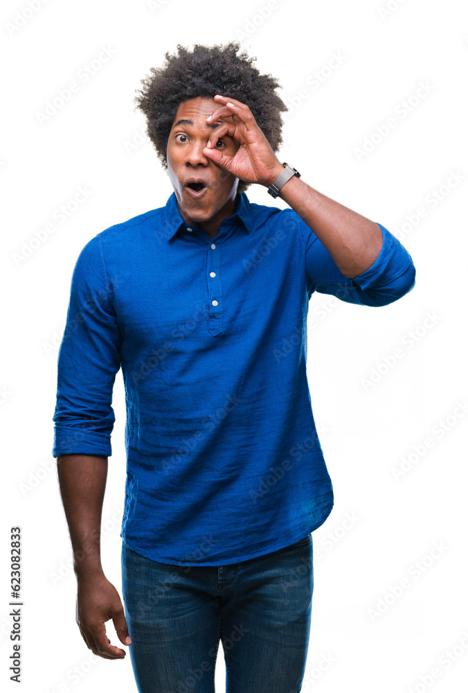 Afro american man over isolated background doing ok gesture shocked with surprised face, eye looking through fingers. Unbelieving expression. Afro american man over isolated background doing ok gesture shocked with surprised face, eye looking through fingers. Unbelieving expression.