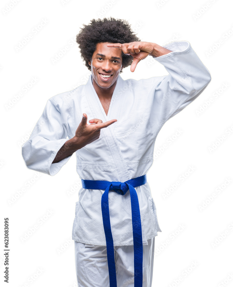 Afro american man wearing karate kimono over isolated background smiling making frame with hands and fingers with happy face. Creativity and photography concept. Afro american man wearing karate kimono over isolated background smiling making frame with hands and fingers with happy face. Creativity and photography concept.