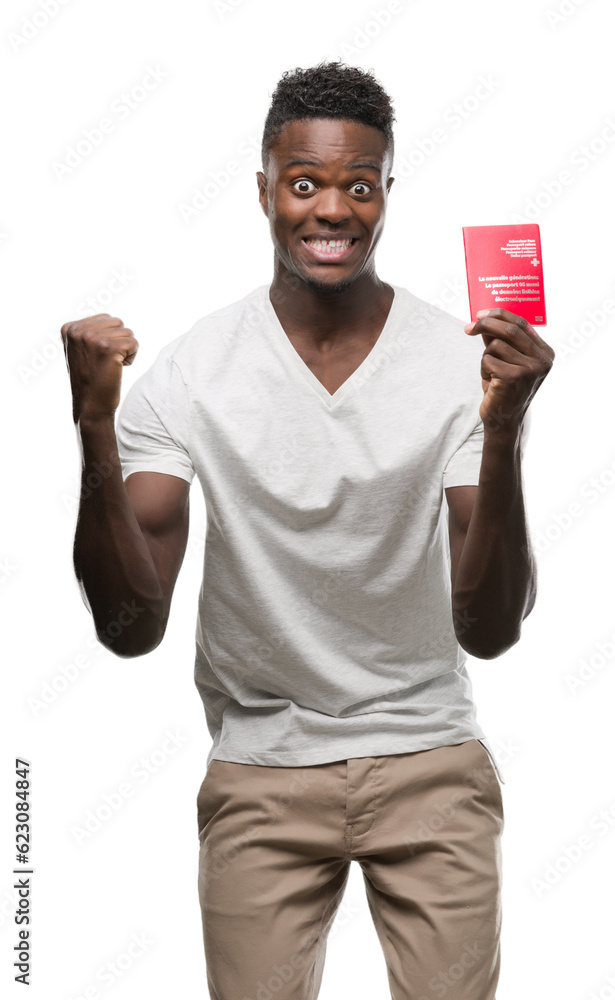 Young african american man holding passport of Switzerland screaming proud and celebrating victory and success very excited, cheering emotion Young african american man holding passport of Switzerland screaming proud and celebrating victory and success very excited, cheering emotion