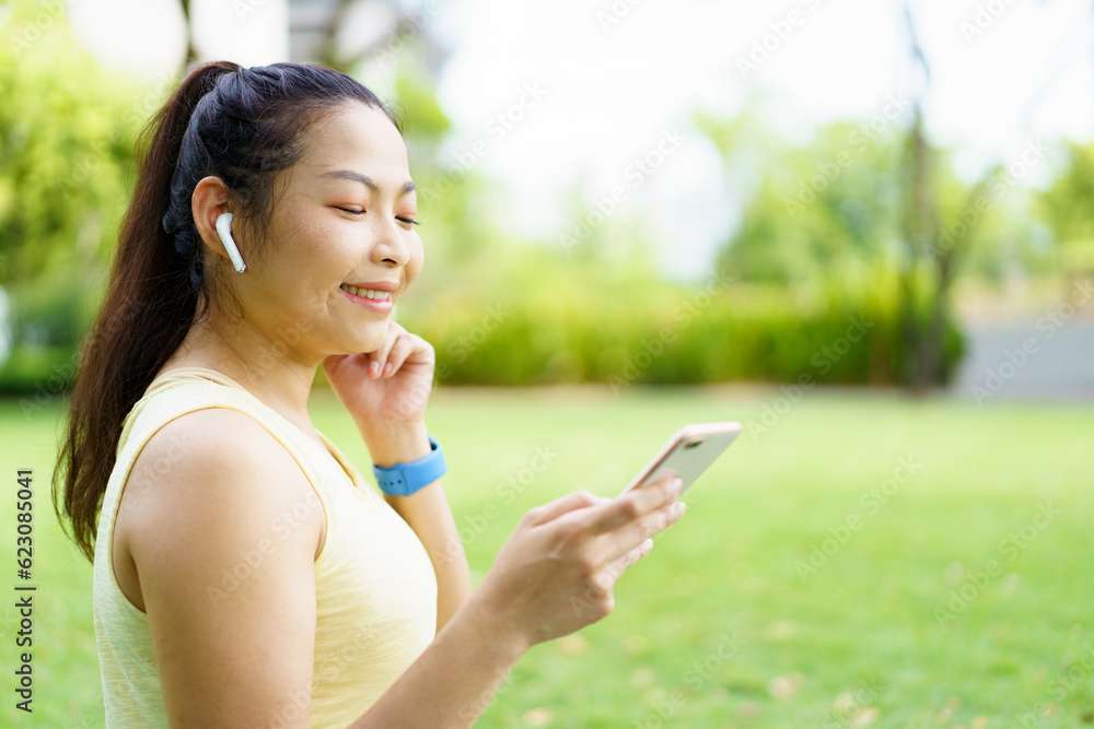 Healthy happy Asian woman enjoy running exercise at the park and listening music on wireless headphone while running. Beautiful Asian woman listening music on an earphones while running. Healthy happy Asian woman enjoy running exercise at the park and listening music on wireless headphone while running. Beautiful Asian woman listening music on an earphones while running.