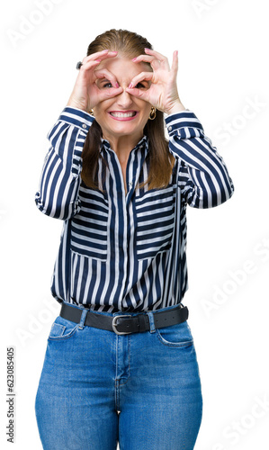 Middle age mature business woman over isolated background doing ok gesture like binoculars sticking tongue out, eyes looking through fingers. Crazy expression.