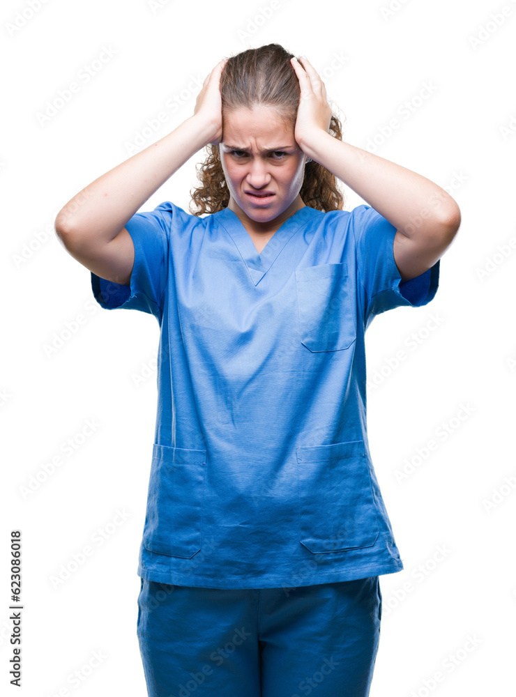 Young brunette doctor girl wearing nurse or surgeon uniform over isolated background suffering from headache desperate and stressed because pain and migraine. Hands on head.