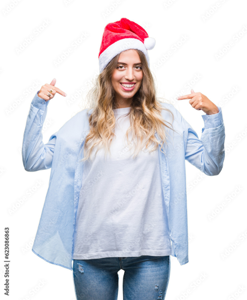 Beautiful young blonde woman wearing christmas hat over isolated background looking confident with smile on face, pointing oneself with fingers proud and happy.