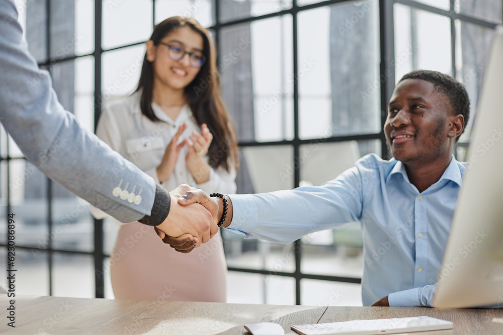 Fototapeta premium happy Middle Eastern and African American partners using laptop computer at table desktop