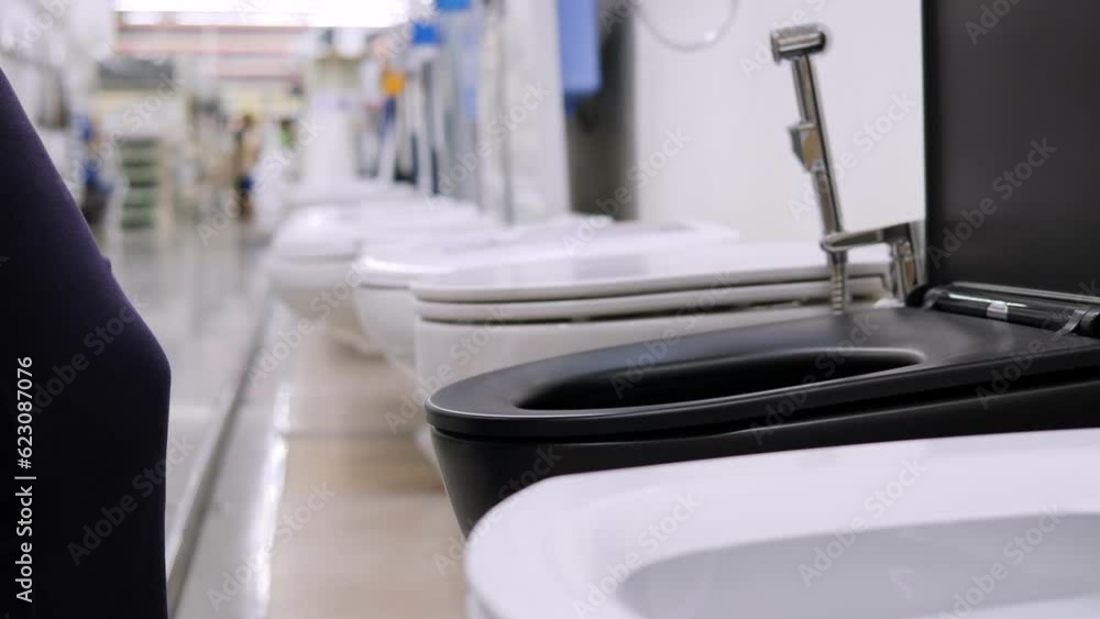 A closeup of a woman chooses toilet bowls with flushing, put up for