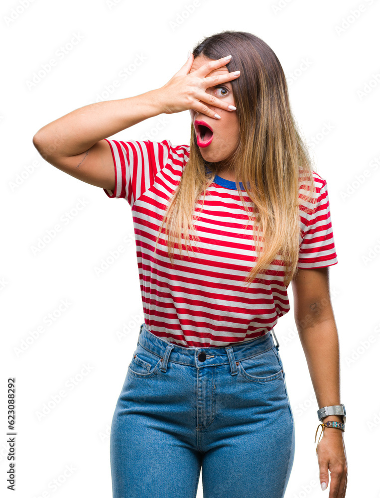 Young beautiful woman casual look over isolated background peeking in shock covering face and eyes with hand, looking through fingers with embarrassed expression. Young beautiful woman casual look over isolated background peeking in shock covering face and eyes with hand, looking through fingers with embarrassed expression.