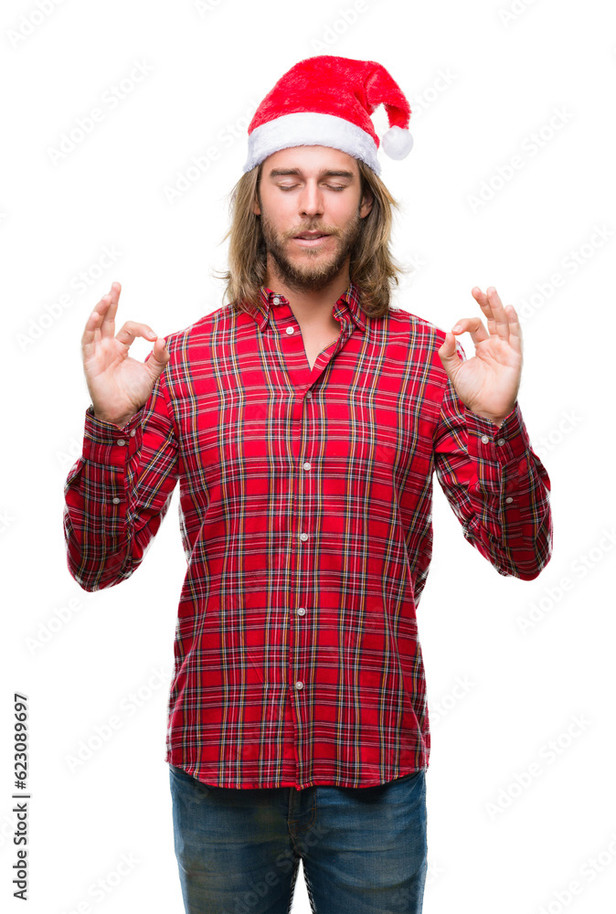 Young handsome man with long hair wearing santa claus hat over isolated background relax and smiling with eyes closed doing meditation gesture with fingers. Yoga concept. Young handsome man with long hair wearing santa claus hat over isolated background relax and smiling with eyes closed doing meditation gesture with fingers. Yoga concept.